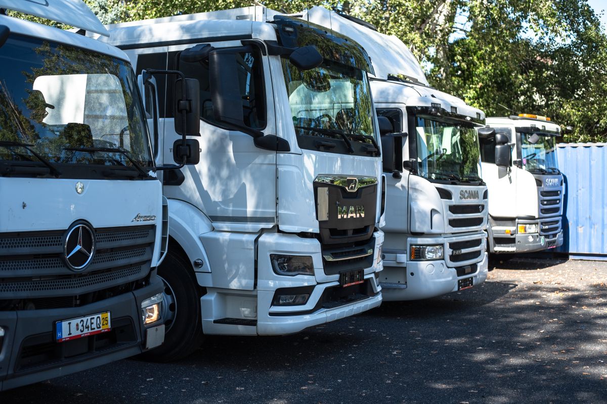 Fehér Mercedes, MAN és Scania teherautók egymás mellett a telephelyen