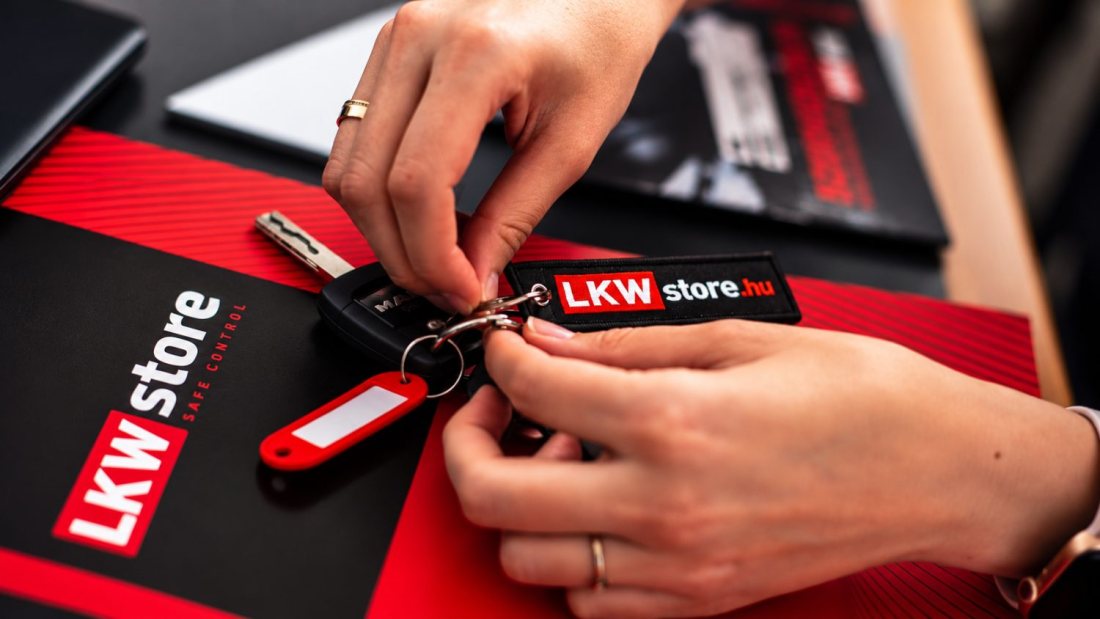 Kulcsátadás LKW Store kulcstartóval, az adásvételi mappa mellett